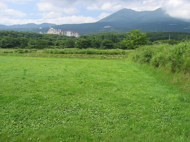 牧草地が広がり、奥には雄大な那須連山を望むことができる。