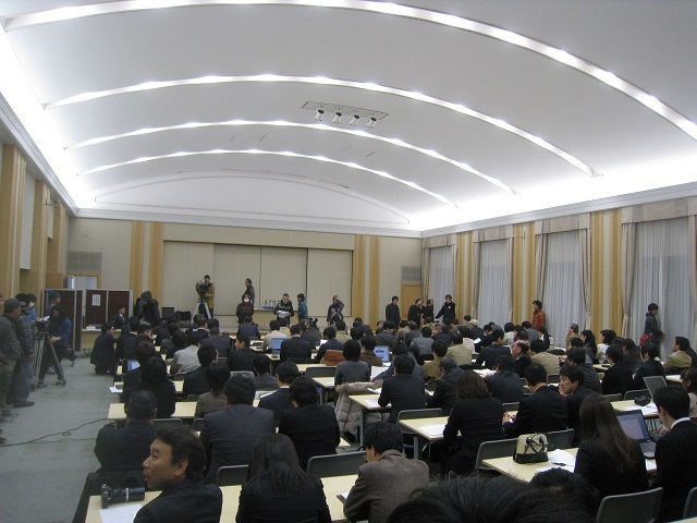 150人を超えるエキストラを募集し、県庁内講堂が記者会見場という設定で撮影されました
