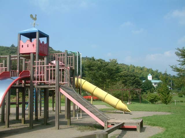 ファミリーパーク子ども向け遊具と奥にはファミリーパークプラザ(洋風建築)。
